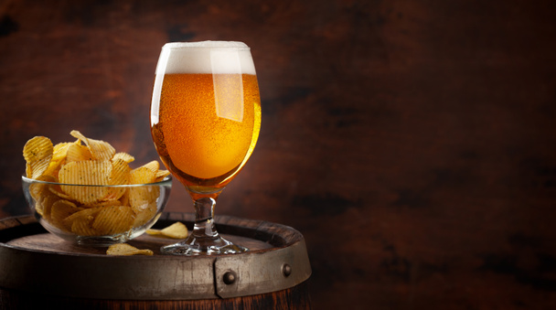 Copa de cerveza y papas fritas en barril de madera. Con espacio de copia - Foto, Imagen