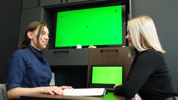 A doctor in a mask shows a laptop with a green screen to a patient. Blank isolated chromatic clef mockup - Séquence, vidéo