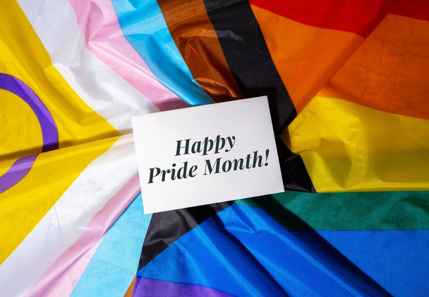 HAPPY PRIDE MONTH inscription positive quote phrase Greeting card on Rainbow LGBTQIA flag made from silk material. Symbol of LGBTQ pride month. Equal rights. Peace and freedom. Support LGBTQIA - Φωτογραφία, εικόνα