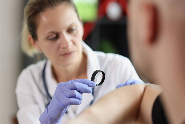 Female doctor examining male patient skin at consultation in medical clinic. Close-up of dermatologist checking patients skin problems. - Photo, Image