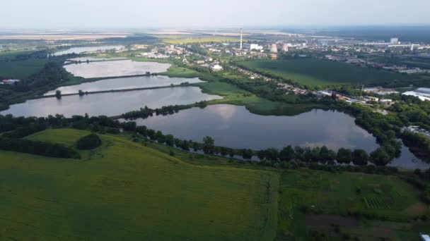 Beautiful panoramic urban landscape on summer day. Industrial lakes for fish farming, agricultural farm fields, city Industrial Zone building, thermal power plant. Aerial drone view. Top view - Filmmaterial, Video