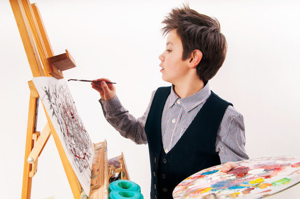 Artiste école garçon peinture pinceau aquarelle portrait sur un chevalet
 - Photo, image
