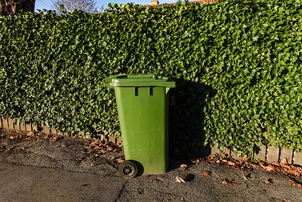 Copenhagen, Denmark A green garbage can on a street in the Amager district. - Фото, изображение