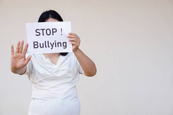 Closeup woman holds paper with text " STOP! Bullying" Concept, campaign for anti bullying, body shaming or parody of others physical appearance. Stop violence.       - Фото, изображение