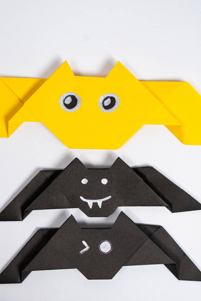 Chauves-souris Halloween, origami bricolage artisanat en papier sur fond blanc, vue de dessus. - Photo, image