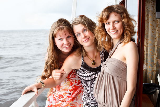 Three beautiful young women a Caucasians standing together on the deck of y - Фото, зображення