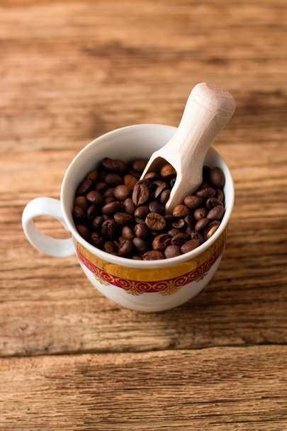 Obersicht auf Tasse mit Kaffeekörnern und Holzlöffel - Foto, Bild