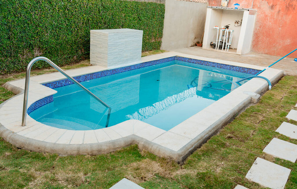 A blue swimming pool with a sand suction hose. A swimming pool with suction hose under water - Foto, immagini