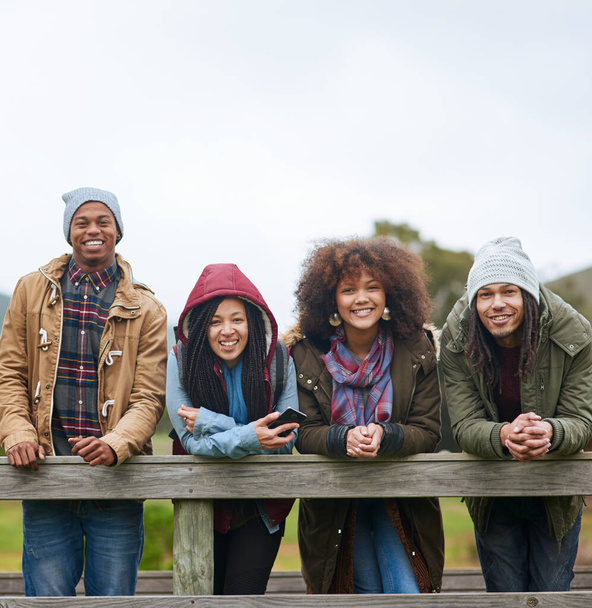 Вийти з міста на вихідні. Портрет групи друзів, які позують на дерев'яному мосту разом
 - Фото, зображення