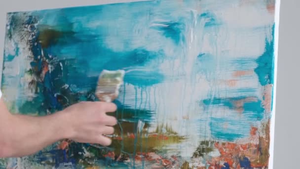 The artist creates an abstract painting in an art studio on a gray background. Modern Art. Painting in blue tones - Кадры, видео