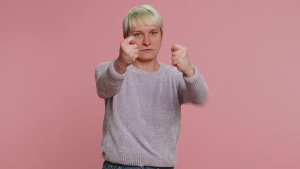 Angry aggressive woman showing fig negative gesture, you dont get it anyway. Rapacious, avaricious acquisitive. Body language. Refusal fig sign. Greedy girl on pink background. Lgbt gay lesbian people - Imágenes, Vídeo