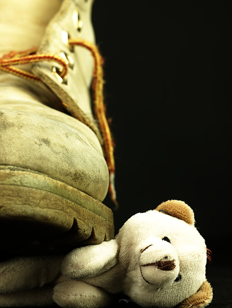 Ağır, eski askeri önyükleme tarafından ezilmiş bir oyuncak ayı. - Fotoğraf, Görsel