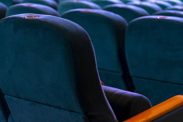 Порожні м'які стільці в концертному залі або кінотеатрі, темний тон
. - Фото, зображення