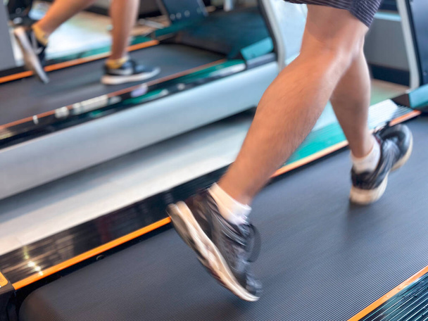 Blur image about man exercising on walking treadmill at gym. Concept for healthy and lose weight. - Foto, immagini