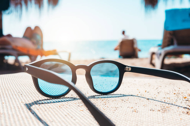 Sunglasses of a tourist on deckchair at a beach - Foto, Imagen