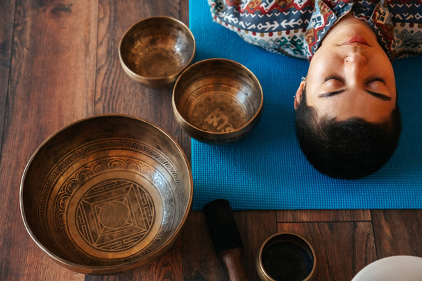 view from above The girl is meditating Tibetan singing bowl in s - Foto, imagen