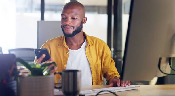 Black man, phone and office chat while online for communication, social media or reading email, news or content creator post. Smile on face of employee at desk for project research on website. - Foto, Imagen