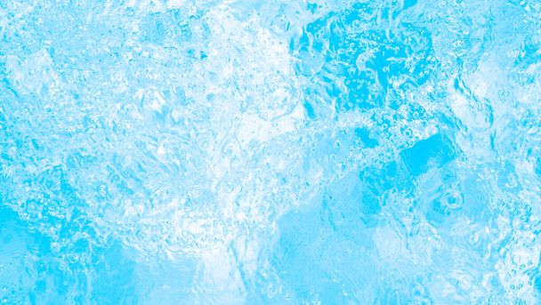 Размытая прозрачная голубая окраска чистой спокойной текстуры поверхности воды со шпильками и пузырьками. Модный абстрактный фон природы. Водные волны в солнечном свете. водный фон - Фото, изображение