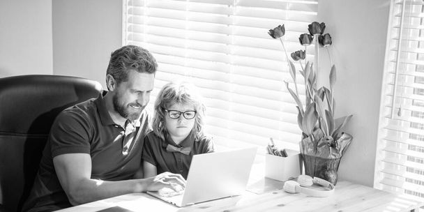 heureux papa aider son fils de l'école enfant dans les lunettes étude avec ordinateur à la maison, la parentalité. - Photo, image