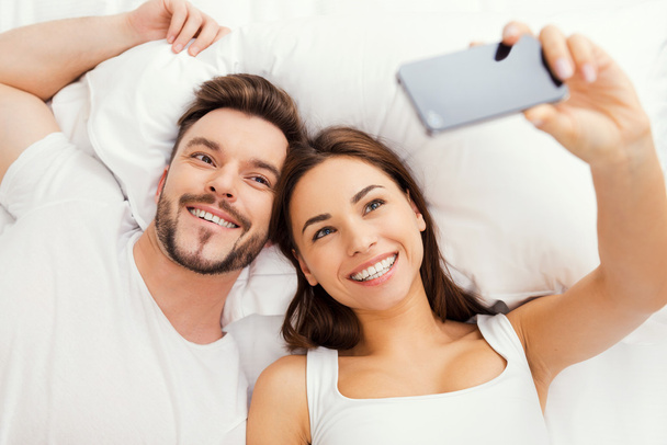 Couple making selfie in bed - Foto, imagen