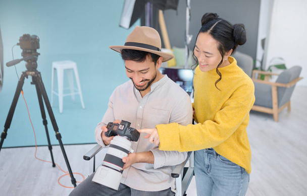 Photography, photographer and model in discussion with a camera choosing a image from the photoshoot. Creative, art and young cameraman talking to woman to choose the best picture in artistic studio - 写真・画像