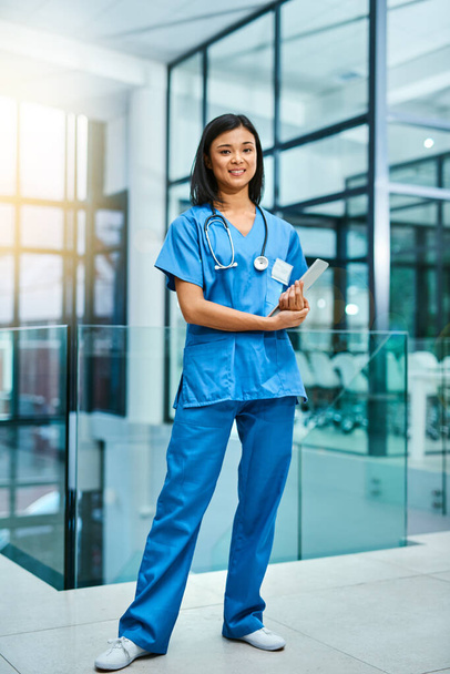 Качественное здравоохранение имеет для меня первостепенное значение. Портрет молодой медсестры, стоящей в больнице - Фото, изображение