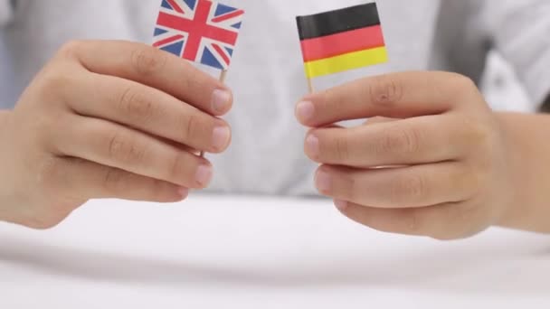 Caucasian boy of 9 years is keeping small flags of UK and Germany. High quality 4k footage - Materiaali, video