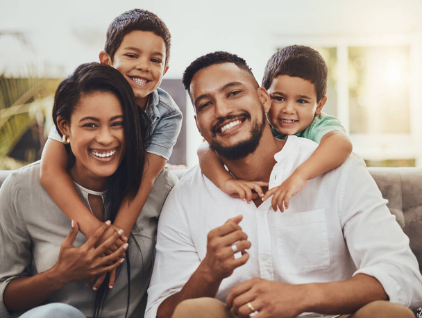 Mother, father and children hug for family portrait with smile relaxing together for holiday or weekend at home. Happy mom, dad and kids smiling for fun hug, love or care in relax on living room sofa. - Foto, afbeelding