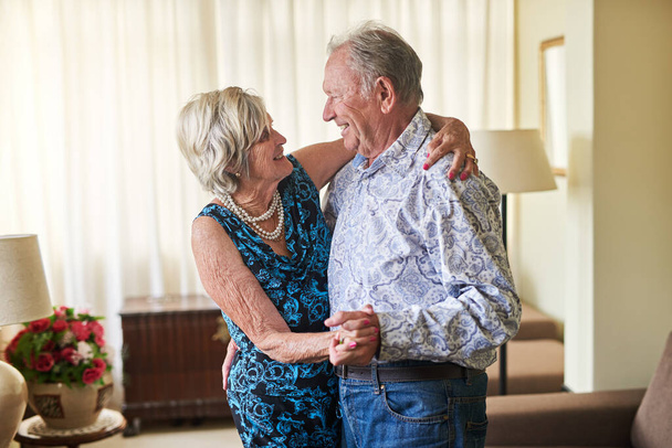 Vieillesse par âge mais jeune de cœur. un heureux couple de personnes âgées dansant ensemble à la maison - Photo, image