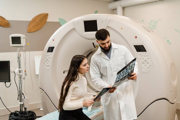 CT Doctor консультує пацієнта і показує рентген грудної клітини пацієнту в кімнаті комп'ютерної томографії. CT сканування радіолог показує рентген живота пацієнту в обчислювальній кімнаті сканування - Фото, зображення