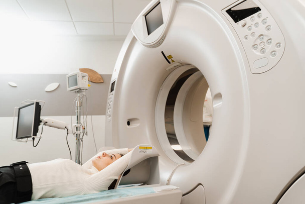 Keuhkosyövän CT-tutkimus klinikalla. Potilas tyttö makaa tietokonetomografia sänky ja skannaus keuhkot diagnosoida keuhkosyöpä lääkäriasemalla - Valokuva, kuva