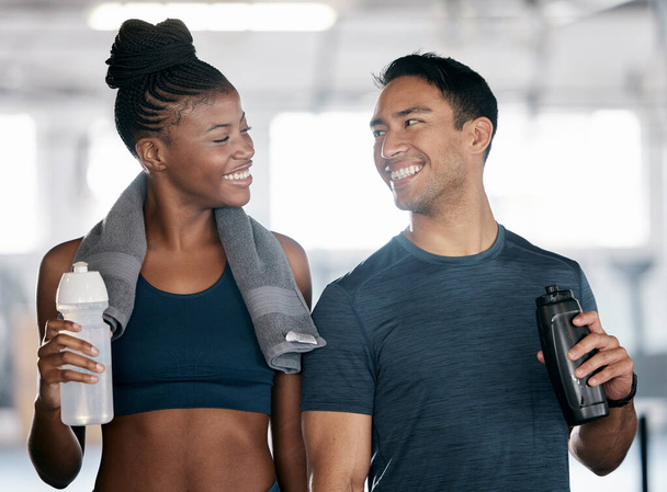 Fitness, black woman or personal trainer drinking water in training, workout or exercise on relaxing break. Coaching, partnership or sports athletes with healthy liquid for hydration or energy at gym. - 写真・画像