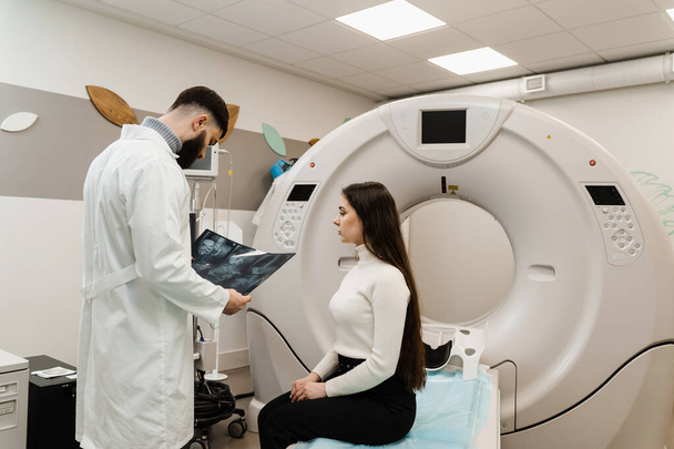 CT Doctor консультує пацієнта і показує рентген грудної клітини пацієнту в кімнаті комп'ютерної томографії. CT сканування радіолог показує рентген живота пацієнту в обчислювальній кімнаті сканування - Фото, зображення