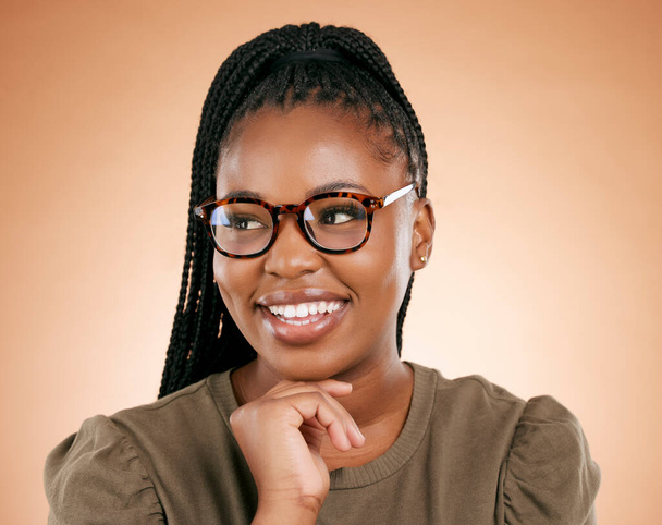 Black woman, glasses and happy person in a studio with eyecare, beauty and smile. Brown background, isolated and gen z student with happiness feeling relax about youth thinking with hipster fashion. - Foto, immagini