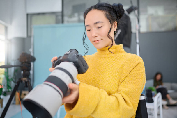 Photography camera, asian woman and digital agency worker review pictures in a studio. Photographer, production process and professional photoshoot with a creative employee checking catalog results. - Photo, Image