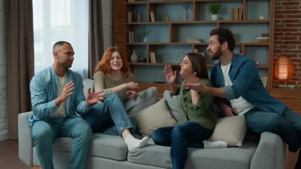 Group of diverse ethnic multiracial friends girls guys sit on sofa at home talking argue conflict friendly dispute debate discussing problem ambitious expressive men women arguing discussion indoors - Video