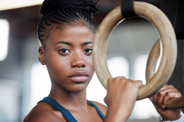 Fitness, gymnastics and portrait of a black woman with rings for training, muscle and arms at gym. Focus, strong and face of an African gymnast with performance during a workout or exercise at a club. - Foto, Imagem