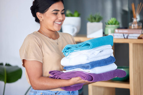 Laundry, housework and towels with a woman cleaner working in a home for domestic hygiene as a maid. Cleaning, hospitality and fabric with a female housekeeper at work in a hotel room or house. - Foto, Imagem