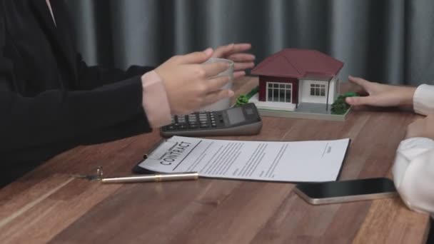 Closeup enthusiastic real estate agency provides client with information and purchase agreement for a house while being advised by estate agent, customer review contract paperwork for house loan. - Footage, Video