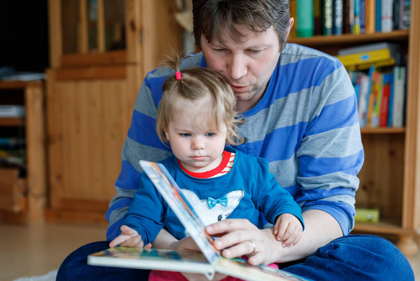 A kaukázusi apa portréja mesekönyvet olvas a kislányával. Otthoni iskola tanulni tanár, oktatás boldog család szeretet együtt, lefekvés ideje történet apák nap koncepció. - Fotó, kép