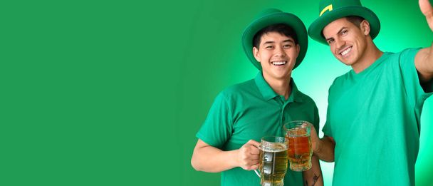 Young men with beer taking selfie on green background with space for text. St. Patrick's Day celebration - Fotografie, Obrázek
