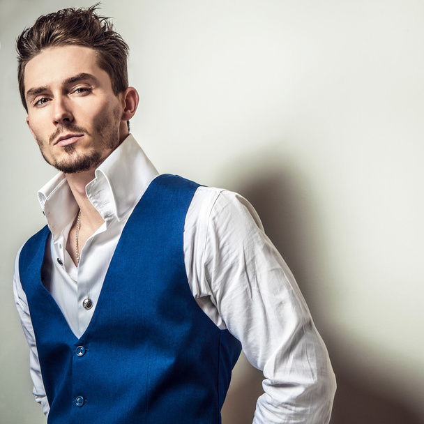 Elegant young handsome man in white shirt & vest. Studio fashion portrait. - Fotó, kép