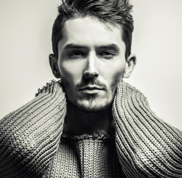 Black-white studio portrait of young handsome man in knitted sweater. Close-up photo. - Photo, Image