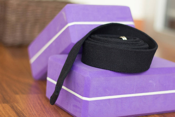 Close up on yoga purple blocks and black belt. Yoga studio material props - Φωτογραφία, εικόνα