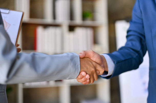 close-up image of two businesspeople shaking hands in the office. congratulations, welcome, greeting, contract, business partnership, cooperation, teamwork. - Zdjęcie, obraz