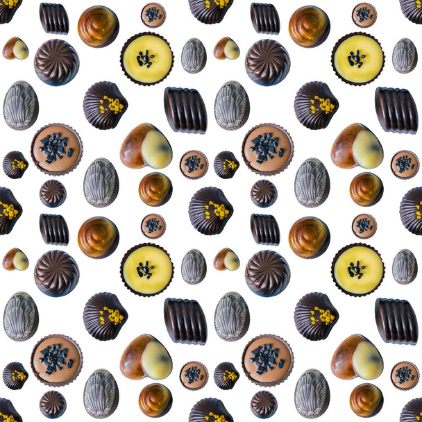 Set of different shapes of dark, white and milk chocolate candies with fillings isolated on white background from above as a pattern - Foto, Imagem