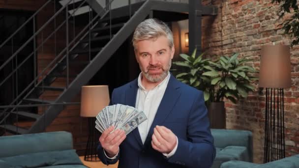 A middle-aged businessman holds a large wad of money in his hands and talks about the possibility of earning money on crypto exchanges, stock market and online casino. Easy winnings in the lottery - Séquence, vidéo