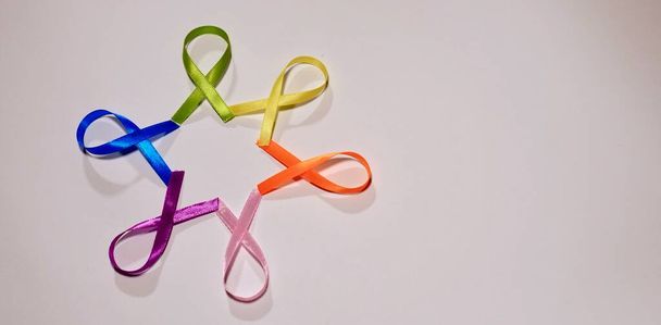 Символ раку з кольоровими стрічками на білому тлі у Всесвітній день обізнаності про рак  - Фото, зображення