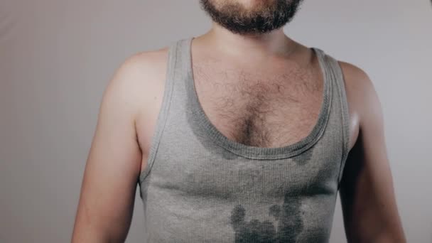 Close up slow motion shoot of strong man in sweaty shirt showing biceps and touching hairy armpits. Refusal of depilation or shaving. Beauty standards, bodypositive, brutal masculinity concept. - Felvétel, videó