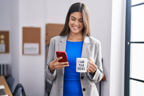 Jovem bela mulher hispânica trabalhador de negócios usando smartphone beber café no escritório - Foto, Imagem